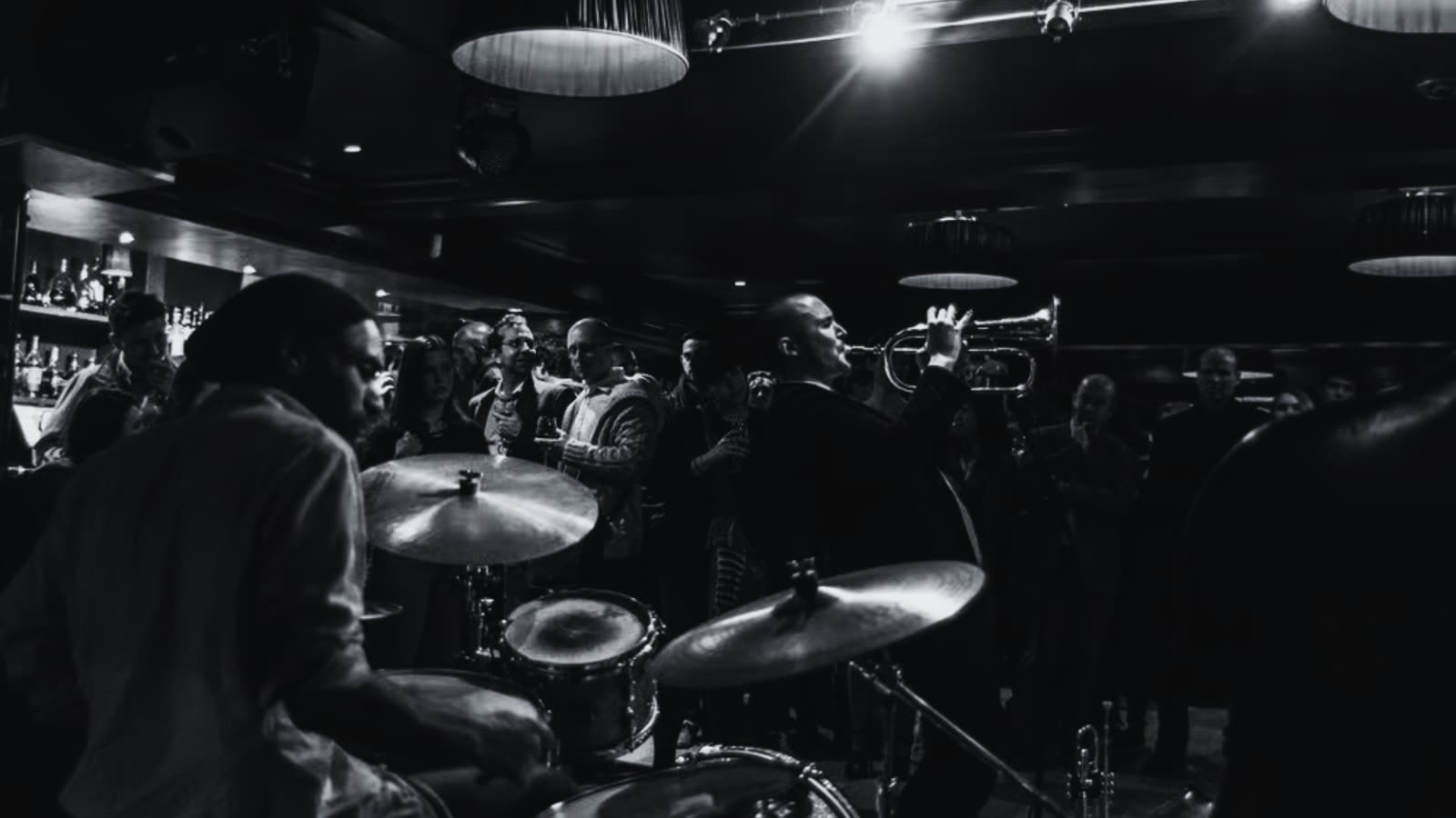 Musicians performing on a small intimate stage in a cocktail lounge.