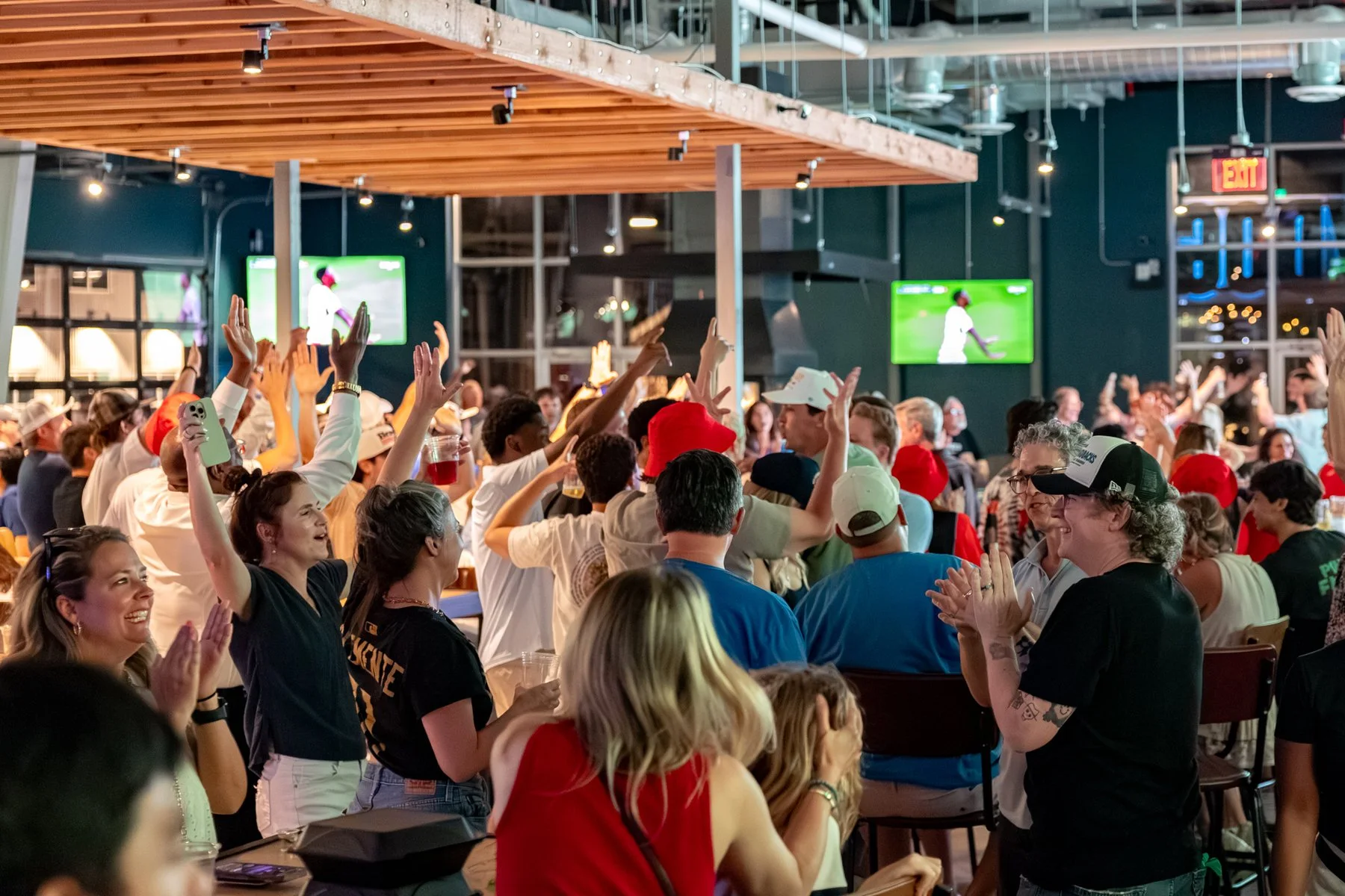 Guests gathered around the bar and big screens at LikeMinds ATL.